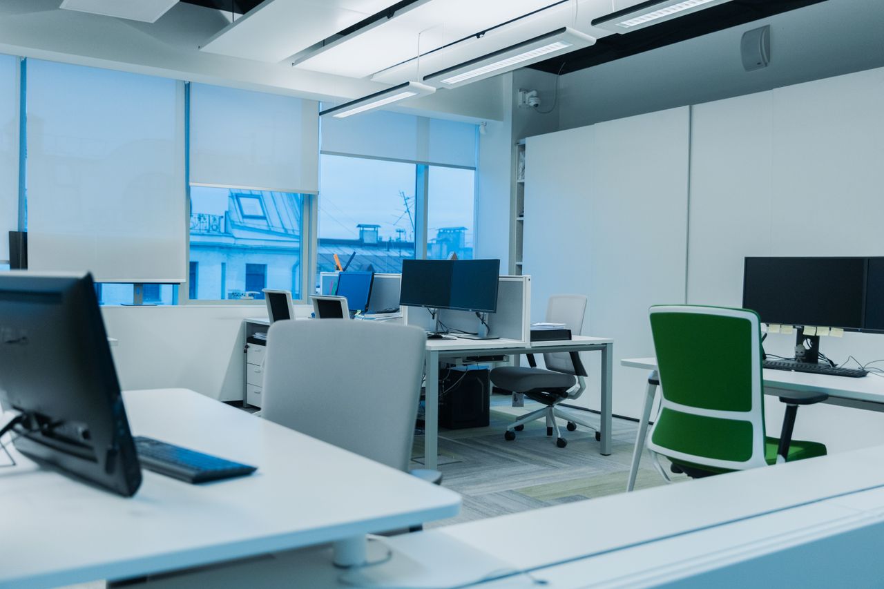 Bright and modern office environment with computer workstations and large windows.